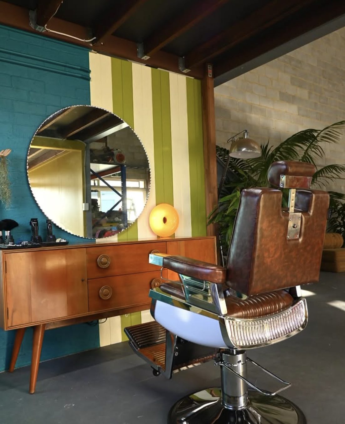 Vintage barber chair and round mirror inside the Spunk studio