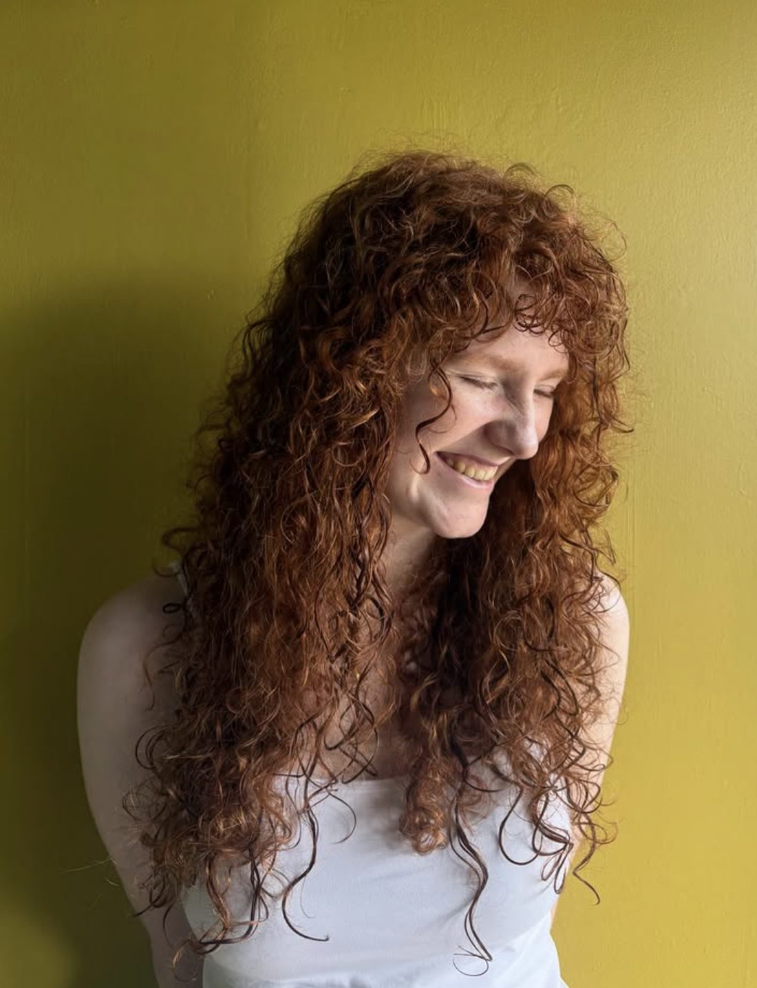 Client with long red curly hair, styled at Spunk
